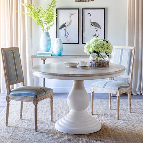 Dining room with Coastal Cottage of Amelia table, chairs, and vase, creating a warm, inviting atmosphere.