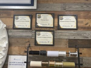 Group of framed Coastal Cottage of Amelia pictures hanging on wooden wall display indoors, showcasing art and décor.